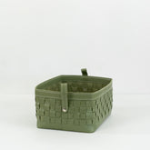 Kara leather storage basket in brown, filled with magazines and toys, placed in a modern living room